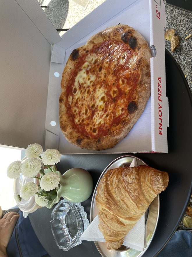 A margherita pizza to take away, with a croissant alongside