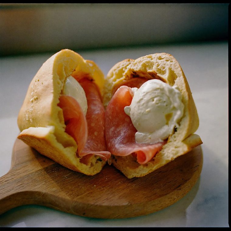 A mortadella and mozzarella panino cut in half