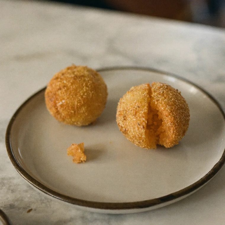 Fried arancini rice balls, one broken open
